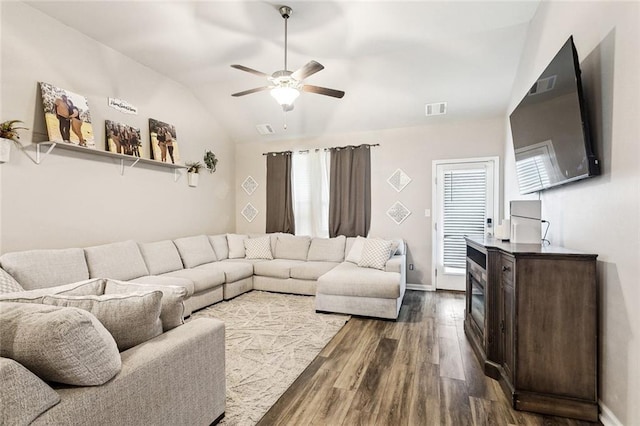 living area with dark wood-type flooring, lofted ceiling, a ceiling fan, and baseboards