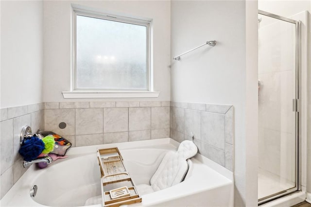 full bathroom with healthy amount of natural light, a shower stall, and a garden tub