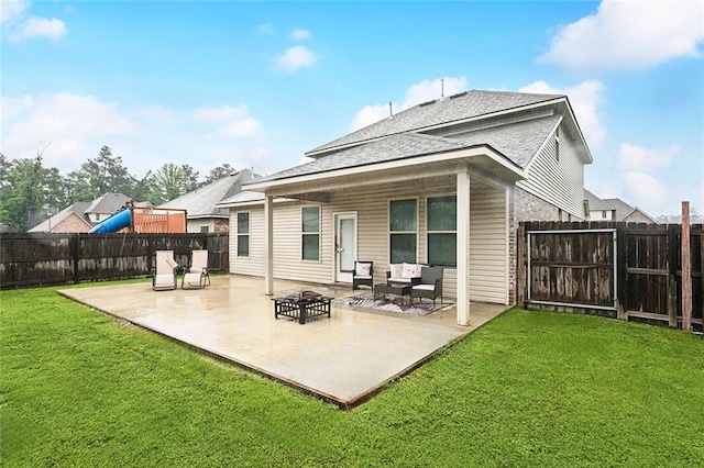 rear view of property with a patio, a shingled roof, and a fire pit