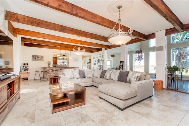 living area with beamed ceiling and light tile patterned floors