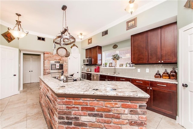 kitchen featuring appliances with stainless steel finishes, an island with sink, a sink, light tile patterned flooring, and tasteful backsplash