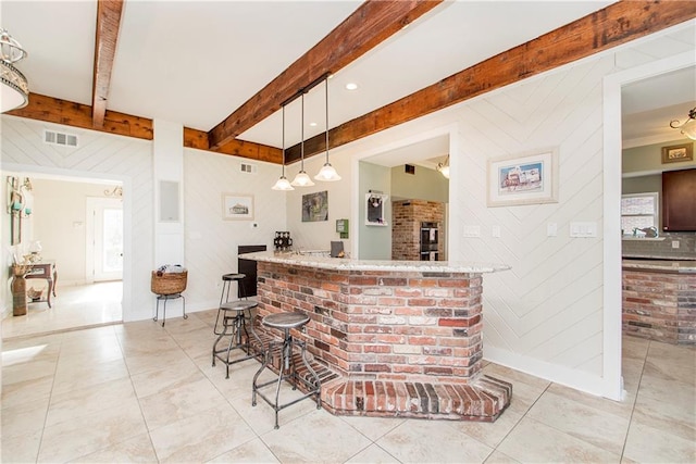 indoor dry bar featuring light tile patterned flooring, beamed ceiling, wooden walls, hanging light fixtures, and baseboards