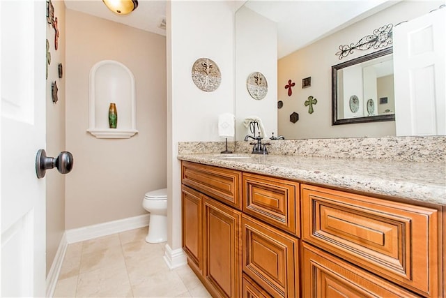 bathroom featuring toilet, vanity, baseboards, and tile patterned flooring