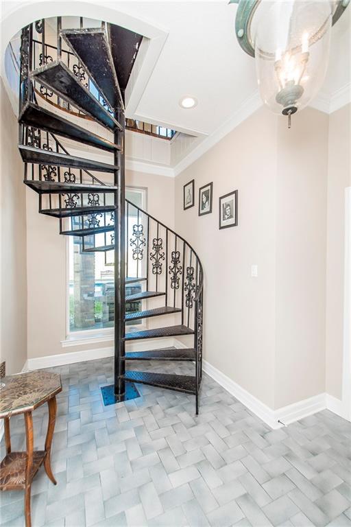 stairway featuring baseboards, crown molding, and recessed lighting
