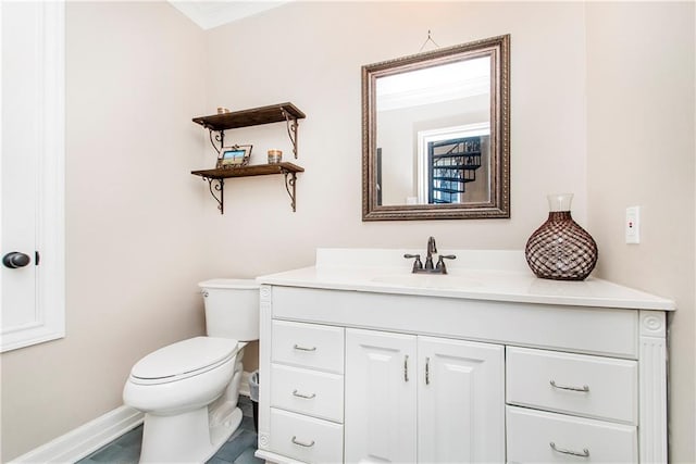 half bath featuring vanity, toilet, baseboards, and crown molding