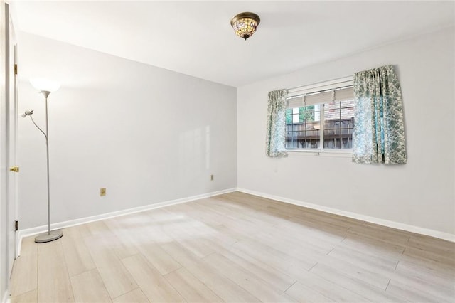 unfurnished room featuring light wood finished floors and baseboards