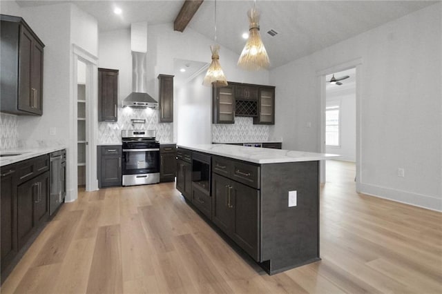 kitchen featuring appliances with stainless steel finishes, light wood-style flooring, decorative backsplash, hanging light fixtures, and a center island
