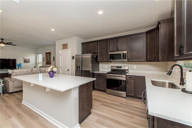 20452 Cornerstone Rd, Hammond, LA 70401 - kitchen featuring stainless steel appliances, a sink, open floor plan, dark brown cabinets, and ceiling fan