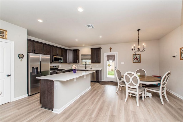 20452 Cornerstone Rd, Hammond, LA 70401 - kitchen with appliances with stainless steel finishes, light wood-style floors, dark brown cabinets, a kitchen island, and recessed lighting