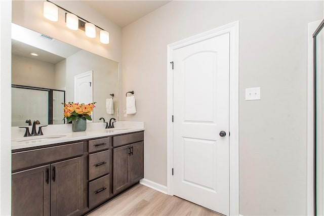 20452 Cornerstone Rd, Hammond, LA 70401 - bathroom featuring wood finished floors, double vanity, baseboards, and a shower stall