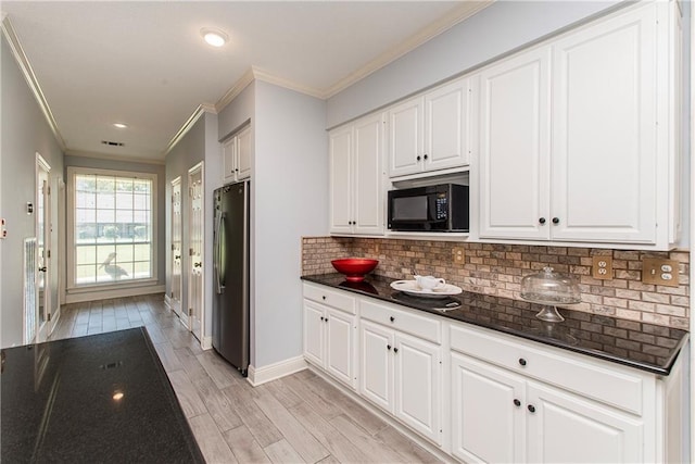 412 Magnolia Ln, Slidell, LA 70461 - kitchen featuring black microwave, freestanding refrigerator, ornamental molding, tasteful backsplash, and baseboards