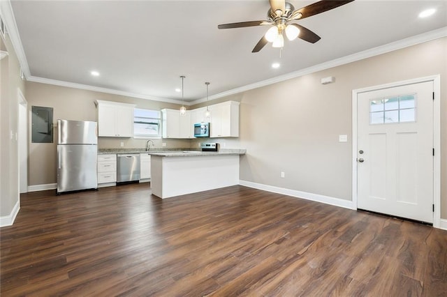 kitchen featuring appliances with stainless steel finishes, plenty of natural light, a peninsula, a ceiling fan, and ornamental molding