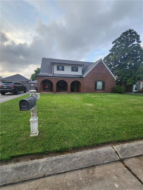 traditional-style house featuring brick siding and a front lawn
