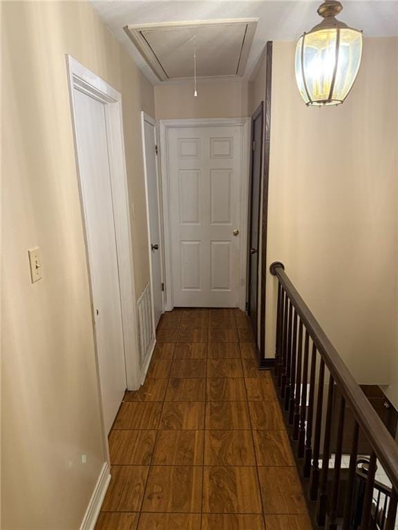 hall featuring attic access and an upstairs landing
