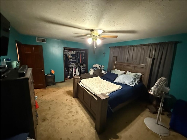 bedroom with ceiling fan, light carpet, and a closet