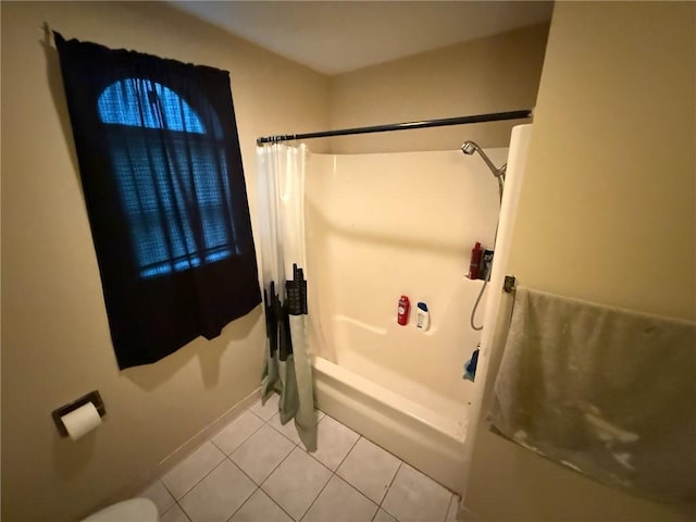 full bath with tile patterned floors, shower / bath combo with shower curtain, and baseboards