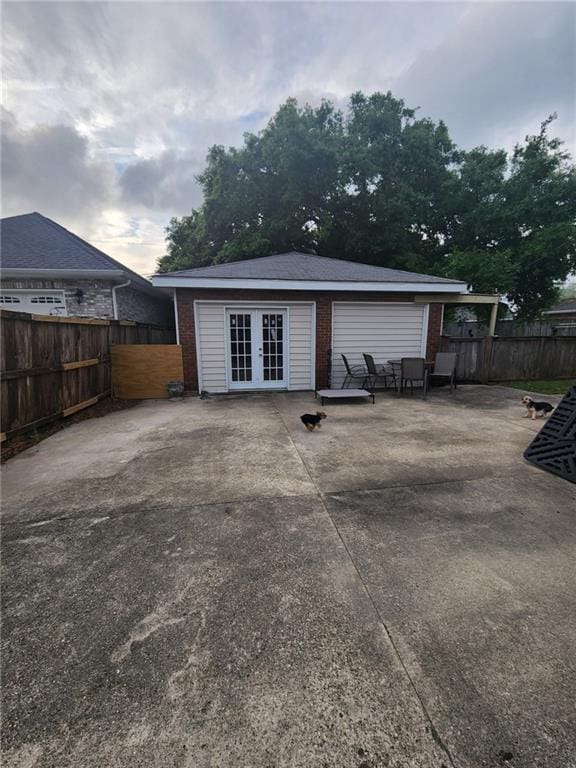 back of house featuring french doors, brick siding, a patio, and a fenced backyard