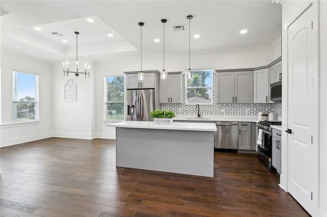 3016 Pecan Dr, Chalmette, LA 70043 - kitchen with appliances with stainless steel finishes, gray cabinets, a center island, dark wood-type flooring, and ornamental molding