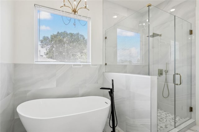 3016 Pecan Dr, Chalmette, LA 70043 - bathroom with tile walls, a freestanding bath, a chandelier, and a stall shower