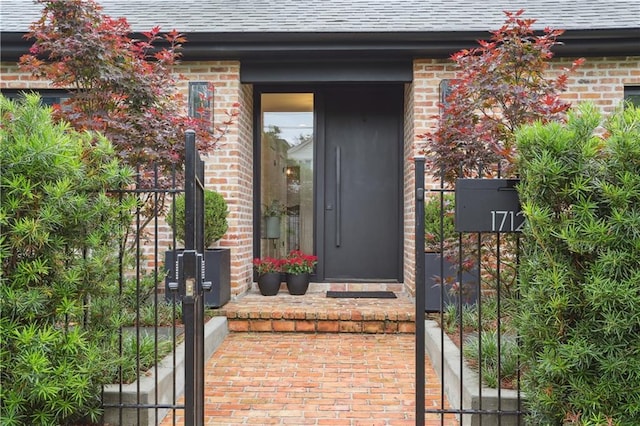 1712 Upperline St, New Orleans, LA 70115 - view of exterior entry featuring brick siding and a shingled roof