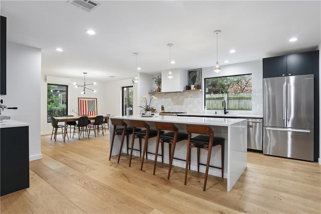 1712 Upperline St, New Orleans, LA 70115 - kitchen featuring appliances with stainless steel finishes, light countertops, decorative backsplash, light wood-style floors, and recessed lighting