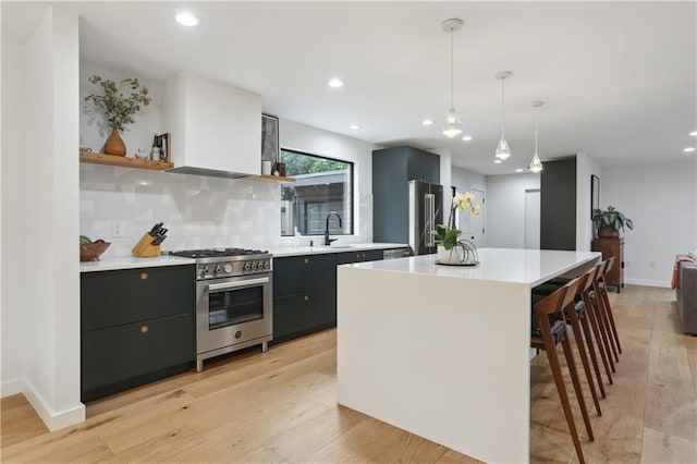 1712 Upperline St, New Orleans, LA 70115 - kitchen with premium appliances, open shelves, light countertops, light wood-style flooring, and a center island