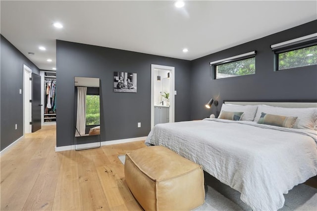 1712 Upperline St, New Orleans, LA 70115 - bedroom featuring light wood finished floors, recessed lighting, a spacious closet, connected bathroom, and baseboards