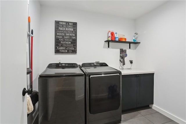 1712 Upperline St, New Orleans, LA 70115 - clothes washing area featuring washing machine and dryer, light tile patterned floors, cabinet space, and baseboards