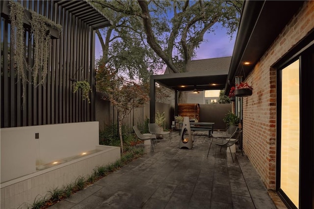 1712 Upperline St, New Orleans, LA 70115 - property exterior at dusk featuring a patio area, a fenced backyard, and brick siding