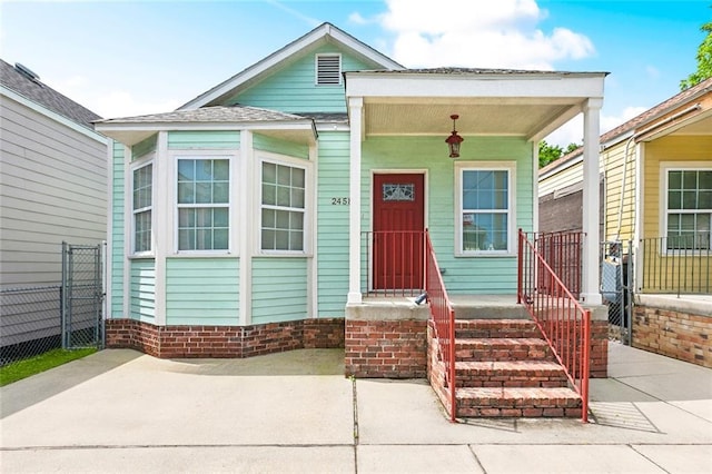 view of front of property featuring fence and covered porch