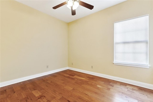 unfurnished room with ceiling fan, baseboards, and wood finished floors