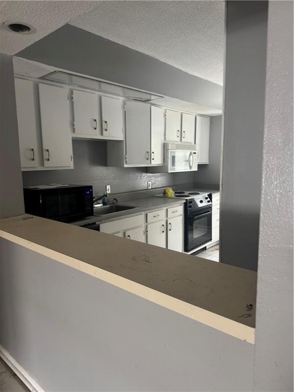 kitchen with black appliances, a sink, a textured ceiling, and white cabinets