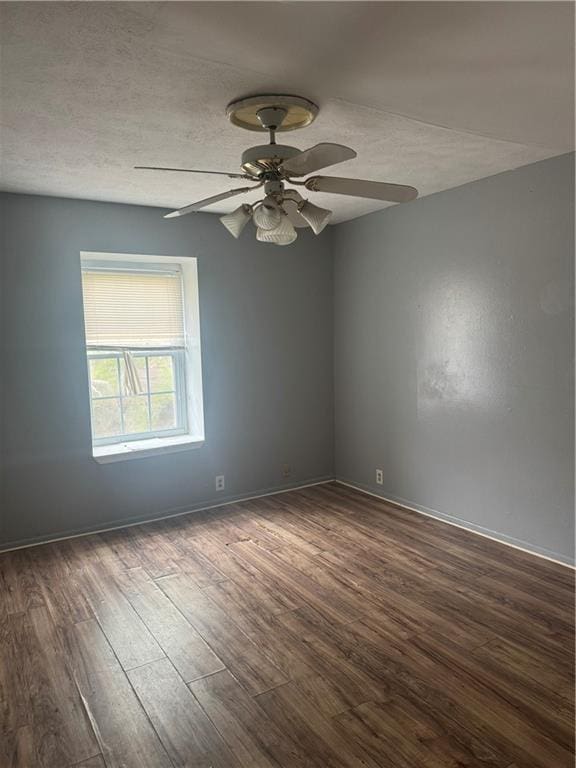 spare room featuring wood finished floors, a ceiling fan, baseboards, and a textured ceiling