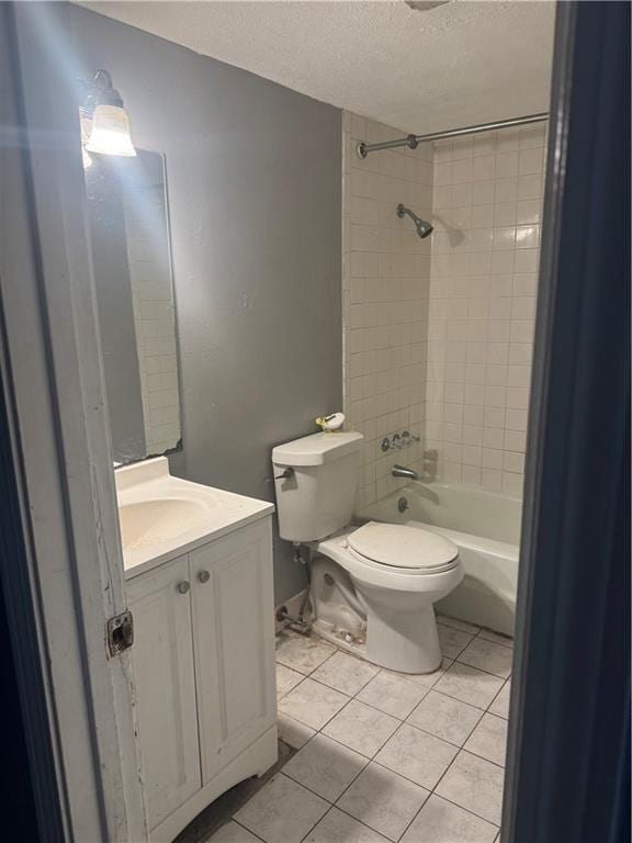 bathroom featuring a textured ceiling, tile patterned floors, toilet, vanity, and shower / washtub combination