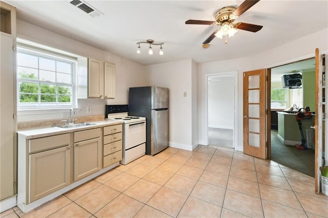 510 Nursery Ave, Metairie, LA 70005 - kitchen featuring white range with electric stovetop, a sink, freestanding refrigerator, light countertops, and light tile patterned floors