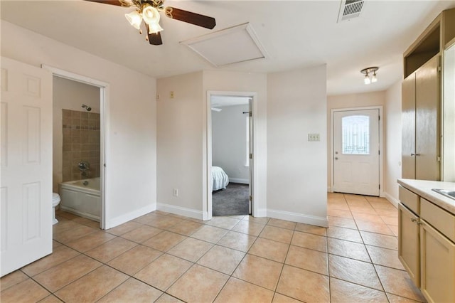 510 Nursery Ave, Metairie, LA 70005 - unfurnished bedroom with light tile patterned floors, baseboards, a ceiling fan, ensuite bathroom, and attic access