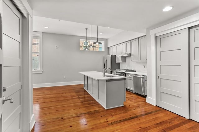 1215 Louisiana Ave Unit 105, New Orleans, LA 70115 - kitchen featuring stainless steel appliances, baseboards, light countertops, decorative backsplash, and wood finished floors