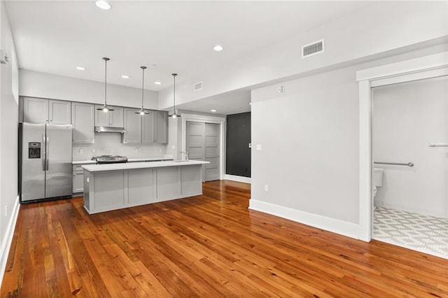 1215 Louisiana Ave Unit 105, New Orleans, LA 70115 - kitchen featuring appliances with stainless steel finishes, gray cabinetry, under cabinet range hood, light countertops, and recessed lighting