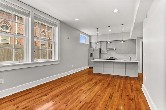 1215 Louisiana Ave Unit 105, New Orleans, LA 70115 - kitchen with stainless steel fridge with ice dispenser, gray cabinetry, hardwood / wood-style flooring, a sink, and light countertops