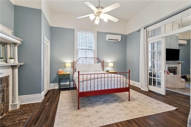 1614 Governor Nicholls St Unit 1, New Orleans, LA 70116 - bedroom featuring a fireplace, a wall unit AC, wood finished floors, and baseboards