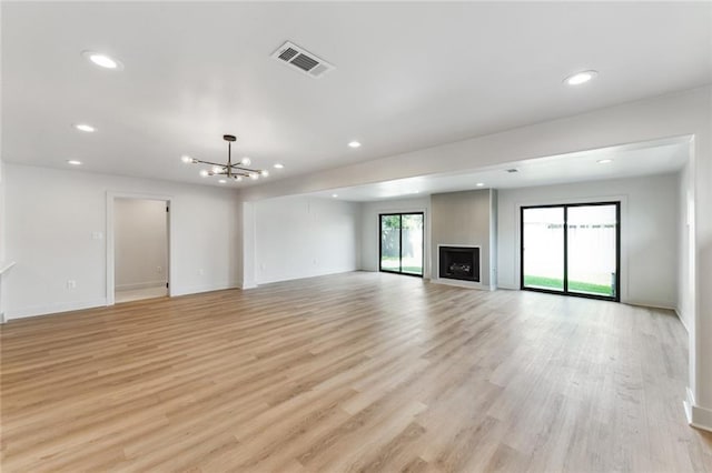 unfurnished living room with a chandelier, recessed lighting, light wood-style flooring, baseboards, and a fireplace