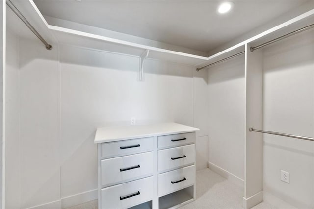 walk in closet featuring light colored carpet