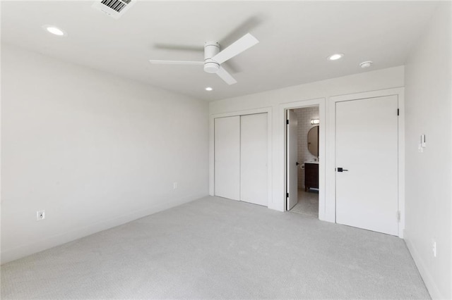 unfurnished bedroom with light carpet, recessed lighting, a closet, ensuite bathroom, and baseboards