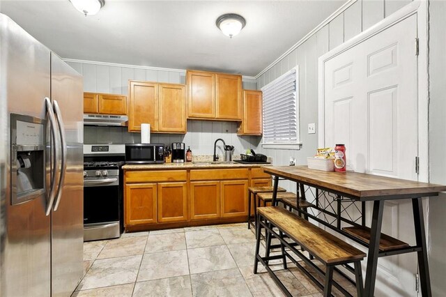 1031 Henriette Delille St Unit 1, New Orleans, LA 70116 - kitchen featuring stainless steel appliances, a sink, under cabinet range hood, ornamental molding, and light countertops
