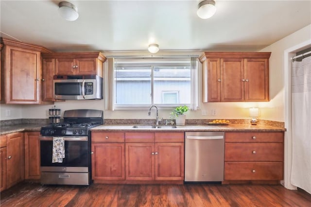 922 Lamanche St, New Orleans, LA 70117 - kitchen featuring appliances with stainless steel finishes, a sink, brown cabinetry, and dark wood-style flooring