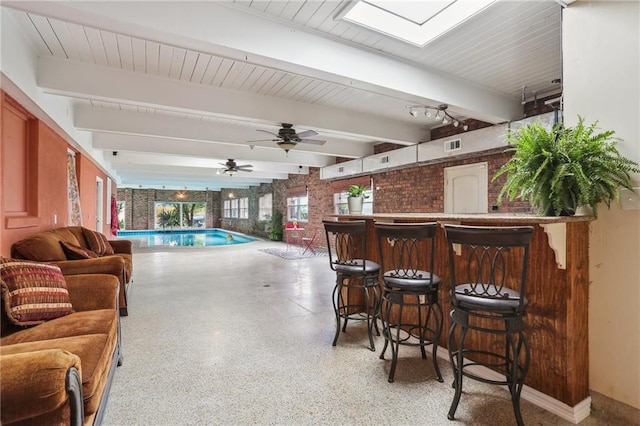 922 Lamanche St, New Orleans, LA 70117 - playroom with speckle patterned floor, a skylight, beam ceiling, bar area, and a pool