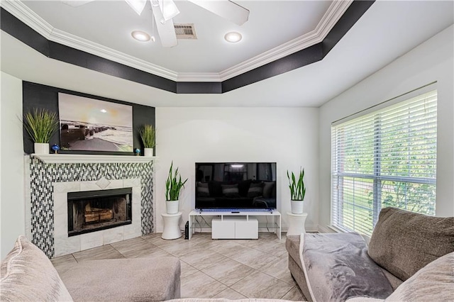 717 Magnolia Ave, La Place, LA 70068 - living area featuring ornamental molding, a tiled fireplace, ceiling fan, tile patterned floors, and a skylight