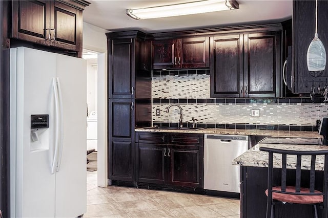 717 Magnolia Ave, La Place, LA 70068 - kitchen with white refrigerator with ice dispenser, stainless steel dishwasher, a sink, backsplash, and dark brown cabinets