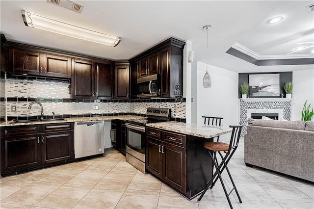 717 Magnolia Ave, La Place, LA 70068 - kitchen featuring stainless steel appliances, a sink, backsplash, crown molding, and light stone countertops