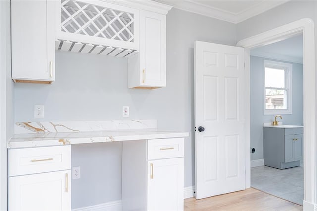 3827 Catherine Ave, Metairie, LA 70001 - kitchen featuring crown molding, white cabinets, light wood-style flooring, and a sink
